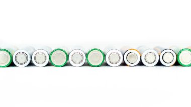 Kullanılan alkali piller beyaz bir arkaplanda izole edilmiş bir sırada yatıyor