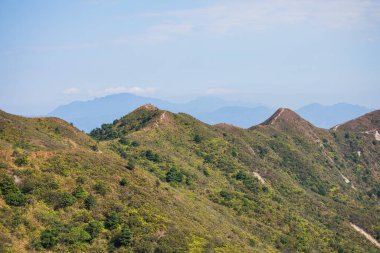 Hong Kong 'un ünlü tatil yeri Sai Kung' un doğusunda, dağda yürüyüş yapan yürüyüşçülerin geniş açılı görüntüleri.