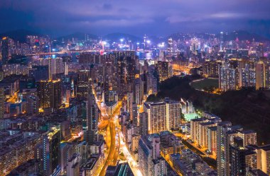 Kowloon, Hong Kong 'daki şehir merkezinin destansı hava gece görüntüsü. Cyperpunk rengi.