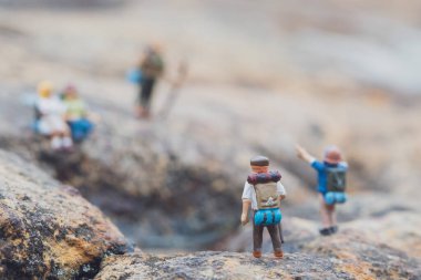 Minyatür yürüyüşçü figürünün eğlenceli konsepti kayalarda, açık havada, gündüz vakti
