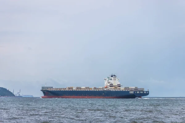 Cargo carrier container on the sea, in a cloudy day