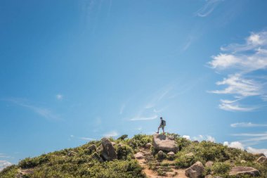 Yürüyüş yapan adam küçük bir tepenin zirvesinde duruyordu. amaç ve başarı, yaz