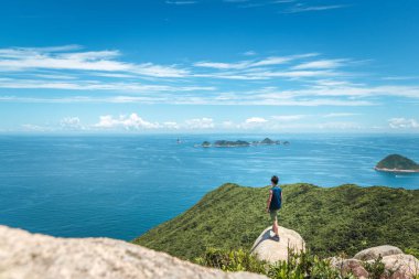 Yaz mevsiminde, okyanusun kıyısındaki yarığın üzerinde yürüyen adam.