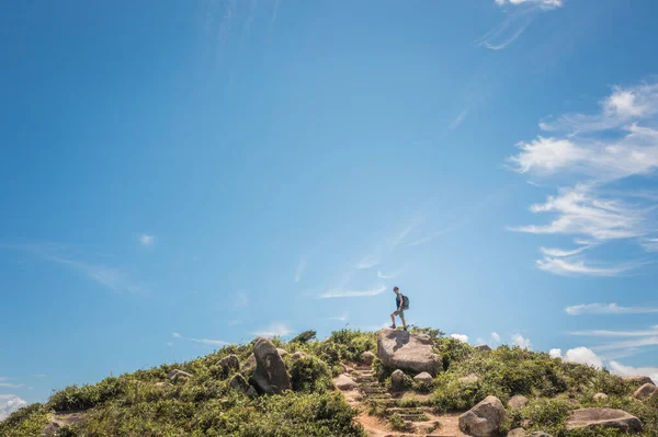 Yürüyüş yapan adam küçük bir tepenin zirvesinde duruyordu. amaç ve başarı, yaz
