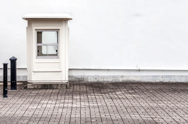 Leere Wache neben einer weißen Mauer — Stockfoto