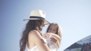 Annesiyle küçük güzel bir kız bankta oturur ve parkta yürür.