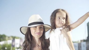 Annesiyle küçük güzel bir kız bankta oturur ve parkta yürür.