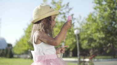 # Küçük güzel kız hava kabarcıkları üflüyor #