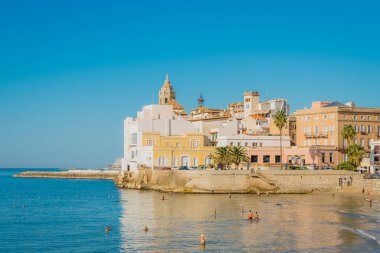 Vista de la costa de Sitges con arquitectura mediterrnea y baistas en el mar