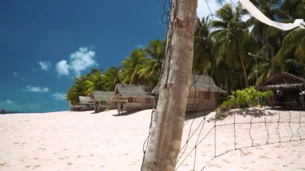 Pequenos bangalôs na praia de areia branca na ilha tropical, rede de vôlei — Vídeo de Stock