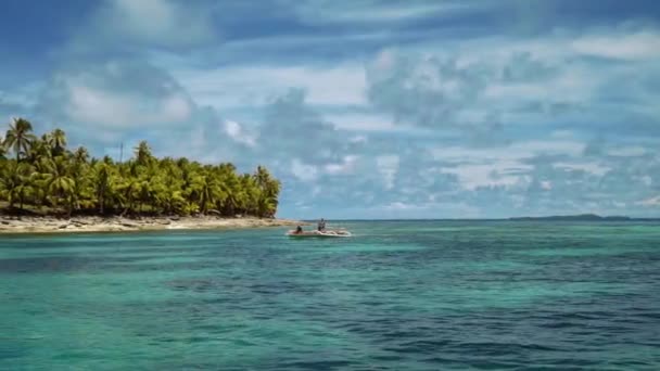Bote outrigger blanco navegando frente a la isla tropical con palmeras — Vídeos de Stock
