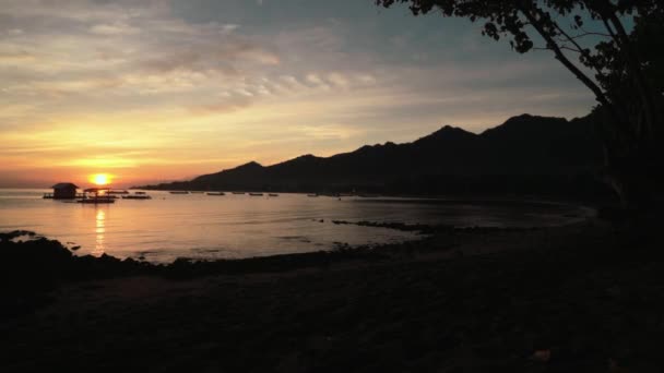 Salida del sol en la bahía de Pemuteran, Bali - cabaña y barcos en el agua — Vídeos de Stock