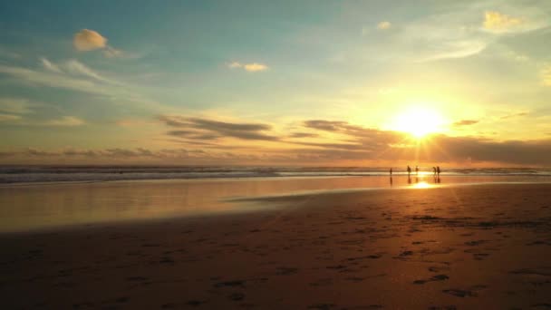 Zonsondergang op het strand van Bali, man loopt naar de zon — Stockvideo