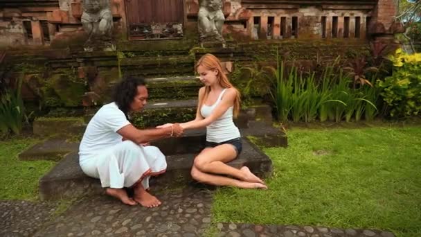 Balinese shaman performs palm reading for european woman — Stock Video