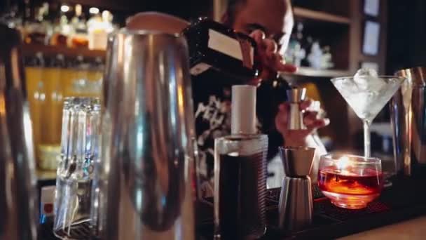 Barman s piercingem a dredy dělat koktejl, přidáním alkoholu — Stock video