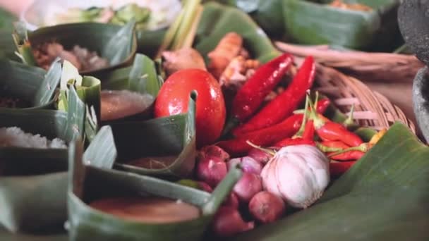 Traditionele balinese ingrediënten voor het koken in palm blad platen — Stockvideo