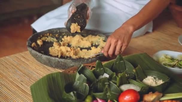 Acabamento moagem de milho com argamassa e pilão, outros ingredientes nas proximidades — Vídeo de Stock