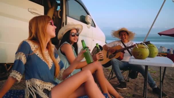 Три друга на пляжном пикнике рядом с фургоном — стоковое видео