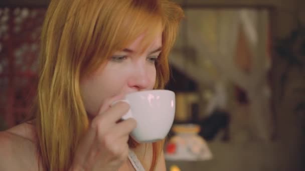 Junge Frau trinkt Kaffee in rustikalem Café — Stockvideo