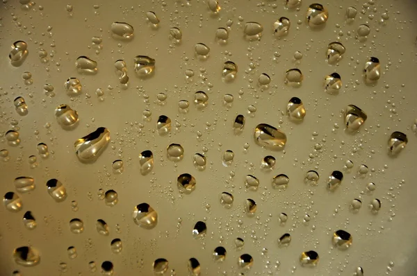 Water drops on the mirror, light brown background.