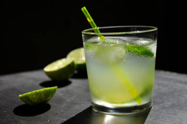 Siyah arka planda buzlu ve limonlu doğal meyve suyu..