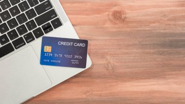 Laptop klavyesindeki mavi kredi kartının yakın çekimi. İnternet satın alma kavramı