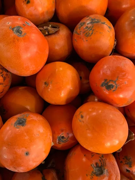 Persimmons te koop aan de toonbank. Straatmarkt. — Stockfoto