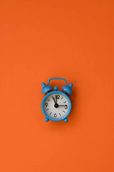 Reloj despertador azul sobre fondo anaranjado.. —  Fotos de Stock