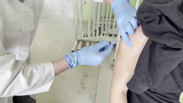 Hand van medisch personeel dat het coronavirus covid-19 vaccin injecteert. — Stockvideo