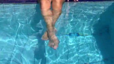 Yüzme havuzunda kadın ayaklarını kapat. Yaz tatili konsepti..