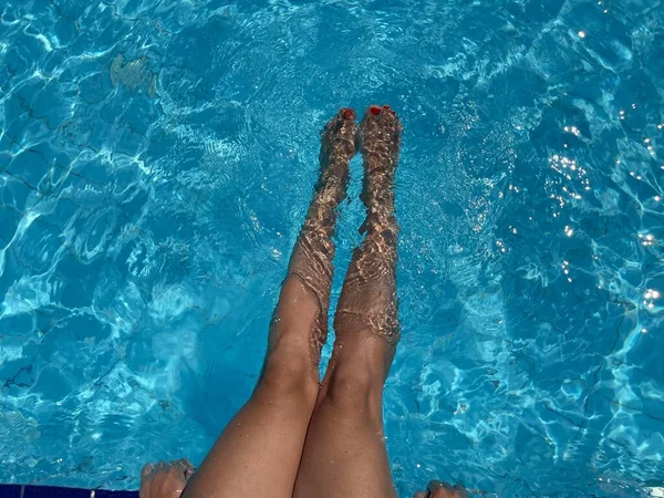 Close up γυναικεία πόδια στην πισίνα.έννοια καλοκαιρινές διακοπές. — Φωτογραφία Αρχείου