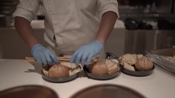 厨师拿着蓝色手套把面包放在银盘里准备好了 — 图库视频影像