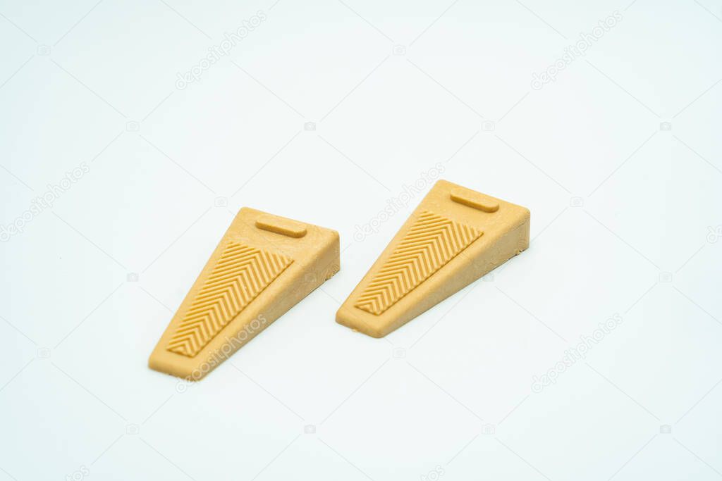 Two brownish door stopper of a peeler with grey grip. Isolated on white background