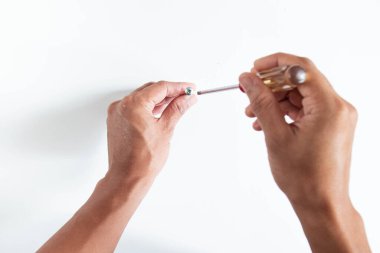 Sağ elini kullanan, Philip 'in tornavidasını tutan ve beyaz arka planda vida takan genç adamın üst açısı.