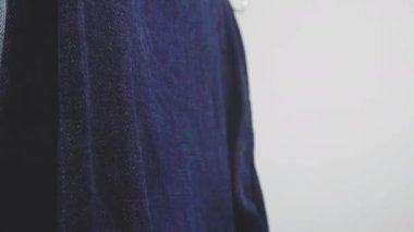 Kamera, askıya kot asan genç bir adamı gösteriyor. 4k görüntü