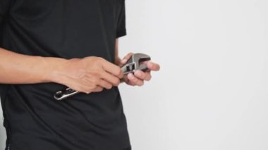 Siyah gömlekli bir adam, beyaz bir arka plan sarar. Beyaz arka planda izole edilmiş. Boşluğu kopyala