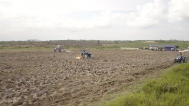 Kuala Lumpur, Malezya: 07 Haziran 2020: Traktörlü bir çiftçi ekin ekimi için tarlayı sürüyor. Toprak hazırlığı. Bir sabanla çalışmak. Büyüyen durian