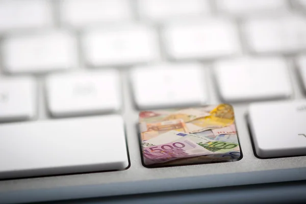 Dinero en euros en el teclado —  Fotos de Stock