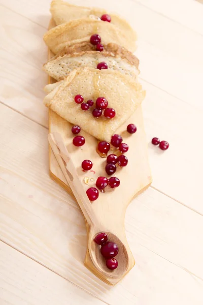 Pancakes folded triangles on a wooden board — Stock Photo, Image