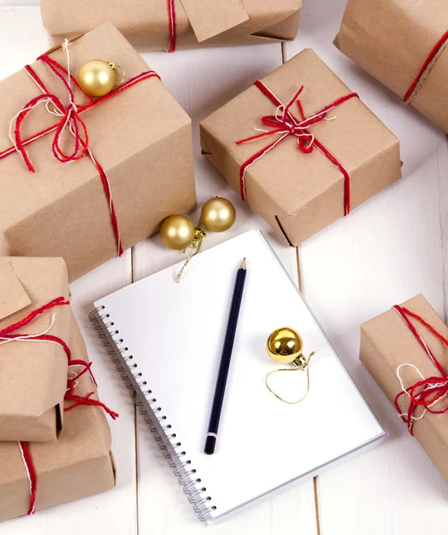 Wish list in to notebook near christmas gifts — Stock Photo, Image