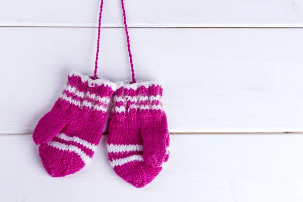 Children's knitted mittens on a wooden background — Stock Photo, Image