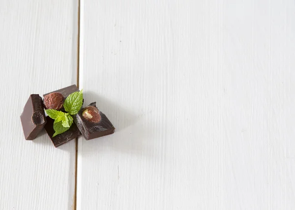 白い木製の背景にミントの葉とダーク チョコレート — ストック写真