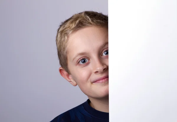 Porträt eines lächelnden Jungen, der hinter einer leeren Platte steht — Stockfoto