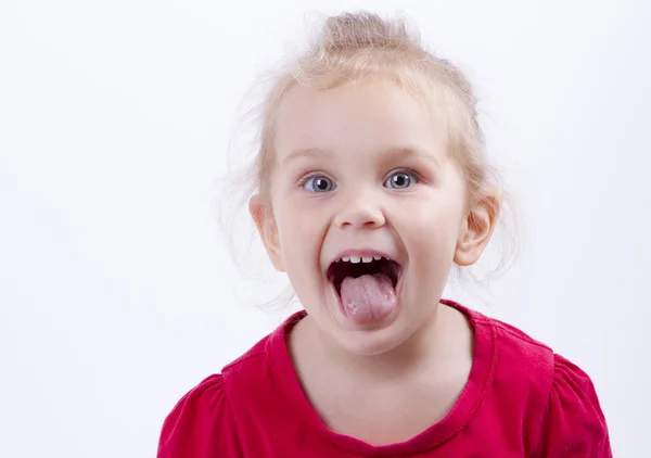 Girl looks in the frame and showing tongue — Stock Photo, Image