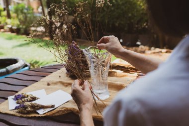 Yaşlı kadın kuru çiçek aranjmanını internetten öğreniyor.