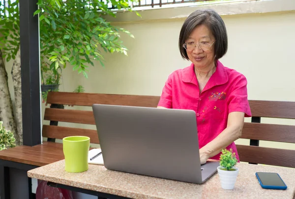 Sênior Reitred Asiático Mulher Usando Computador Para Escrever Mail Sentado — Fotografia de Stock