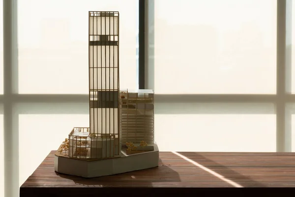 窓の近くのテーブルの上に木や紙で作られた高層ビルの模型 — ストック写真