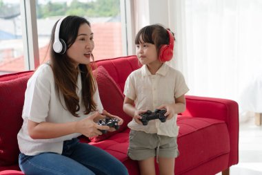 Genç Asyalı çocuk ve anne evde sanal gerçeklik oyunu oynuyorlar. aile kavramı