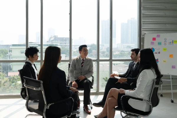 Ofisin penceresinin yanında durup projeyi tartışan Kafkas ve Asyalılar da dahil olmak üzere uluslararası iş ekibi. iş konseptinde çeşitlilik