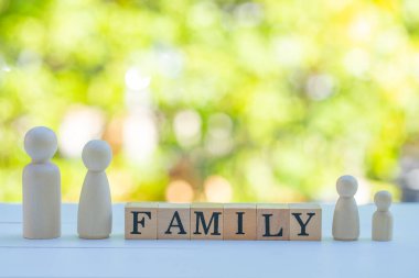 Tahta figürler aileyi temsil ediyor, anne ve çocuklar da dahil. bahçe arkaplanı